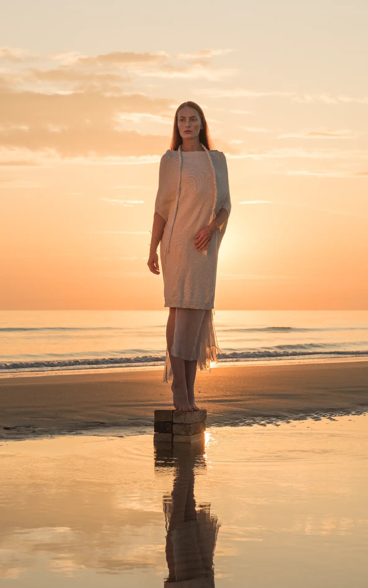 Naga Top Knitted, full-length by the sea at sunset — front