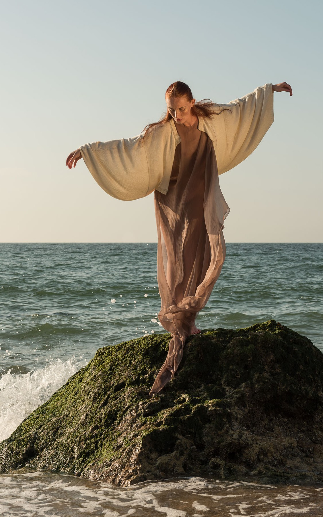 Atun Dress, worn on a rock by the sea